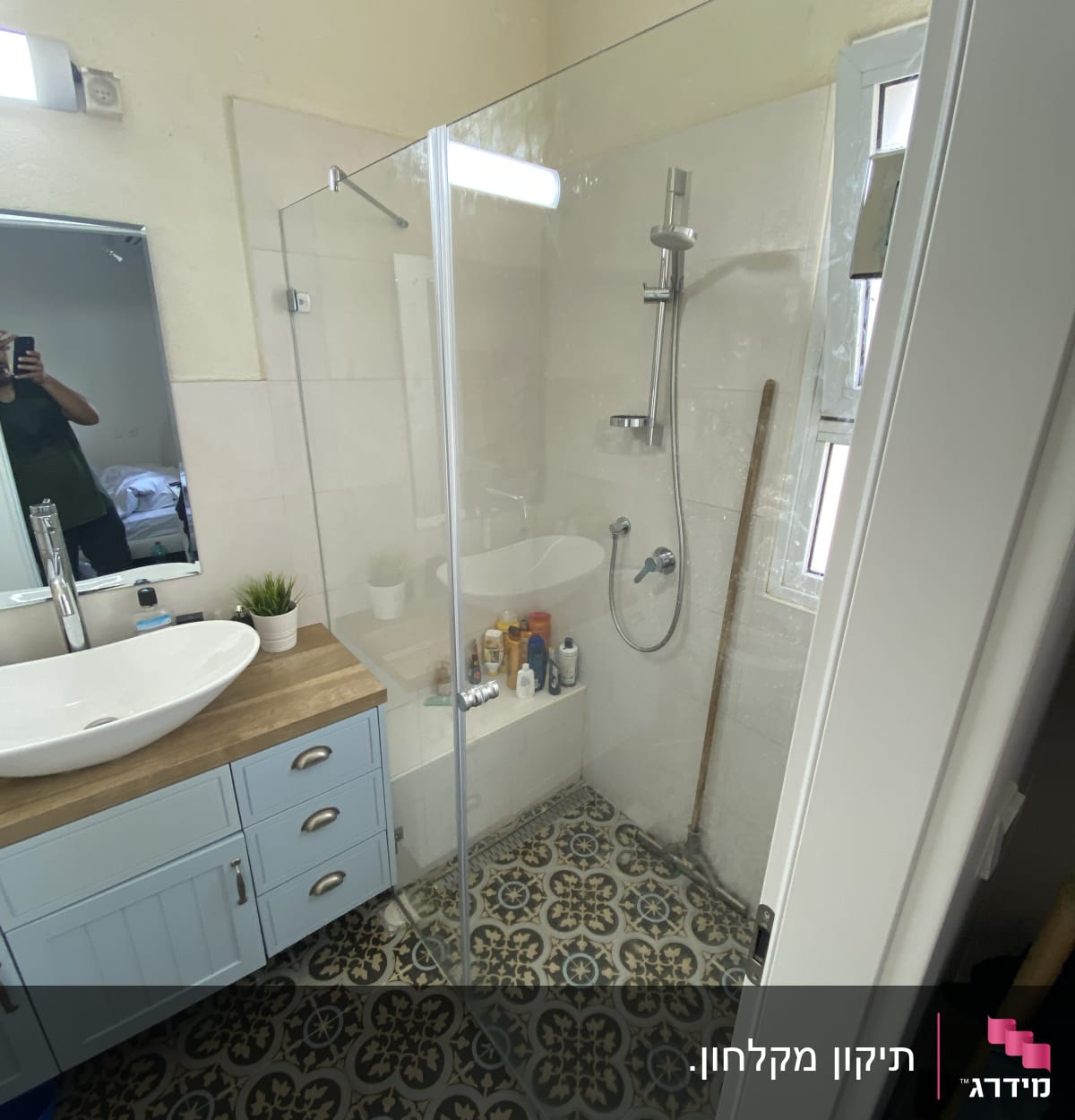 מקלחון זכוכית עם מוצרי טיפוח על המדף